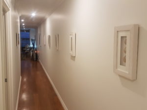 long hallway with timber floor and wall mounted picture frames